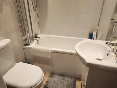 a white bathroom with a toilet and a sink at Largs holiday flat in Largs