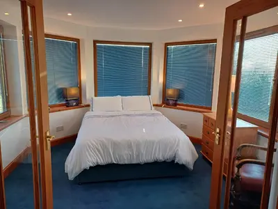 a bedroom with a bed and some windows at North Blairkip Eildon in Sorn