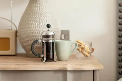 a coffee pot and a cup on a table at The Roseate Edinburgh - Small Luxury Hotels of the World in Edinburgh