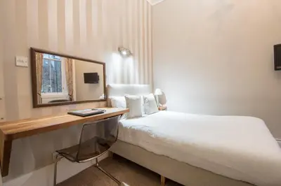 a hotel room with a bed and a mirror at The Belhaven Hotel in Glasgow