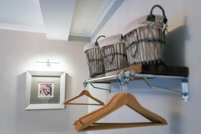 a shelf with two baskets and a picture on a wall at The Belhaven Hotel in Glasgow