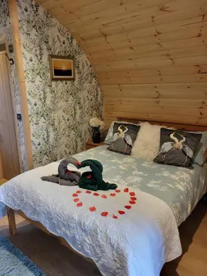 a bedroom with a bed in a wooden room at The Galloway Steading - The Herons Nest, secure garden and with Hot Tub and Fire Pit in Glenluce