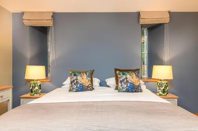 a bedroom with a large bed with two lamps at The Jaw Barn in Milngavie