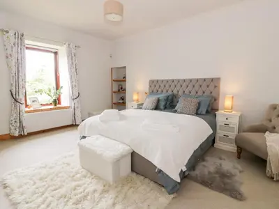 a white bedroom with a large bed and a couch at Shieldhill Farm House in Falkirk