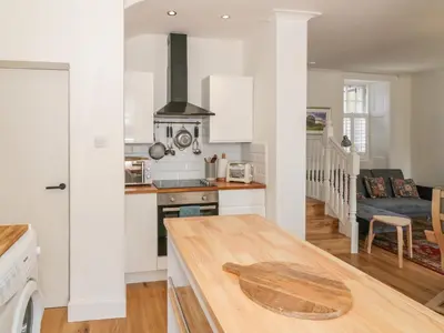 a kitchen and living room with a wooden table at 6 Kirkstyle in Biggar