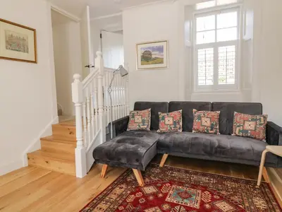 a living room with a black leather couch at 6 Kirkstyle in Biggar