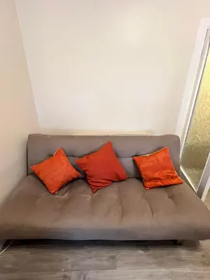 a brown couch with three orange pillows on it at CAMPBELL 100 DUNFERMLINE in Fife