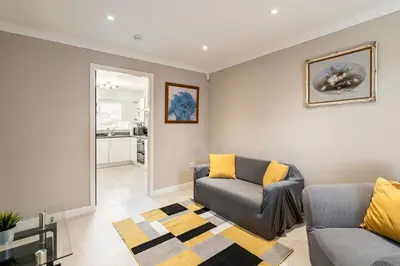 a living room with a couch and a table at Superb 3 Bed Home Away from Home in Glasgow, just off M8 with free parking in Steps