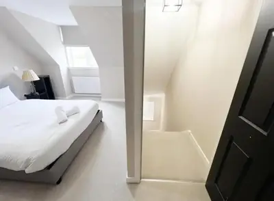 a white bedroom with a bed and a window at Superb 3 Bed Home Away from Home in Glasgow, just off M8 with free parking in Steps