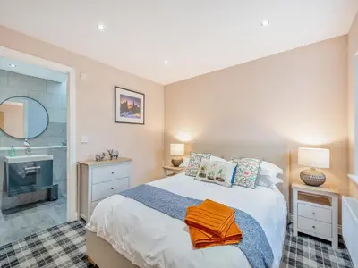 a bedroom with a large bed and a bathroom at The Byre - Uk45343 in Ayr