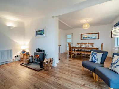 a living room with a wood stove and a dining room at Crarae in Corrie