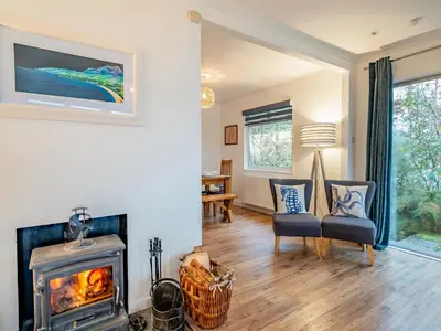 a living room with a fireplace and a stove at Crarae in Corrie