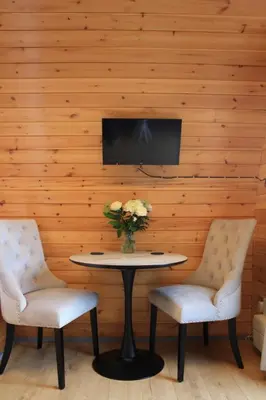 a table with two chairs and a vase of flowers at Loch View Luxury Pod in Connel