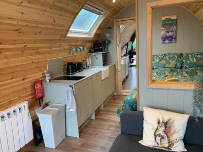 a kitchen and living room in a tiny house at Red Squirrel Pod with Hot Tub in Oban