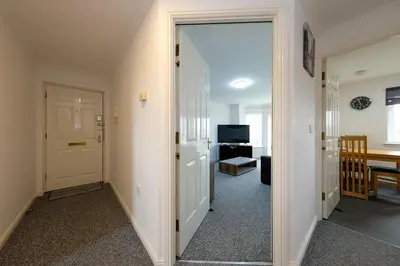 a hallway with a door leading to a living room at Prime Duloch 2nd Floor Apartment by TBA in Fife