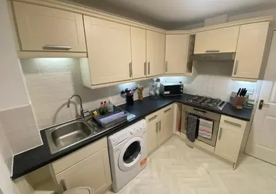 a small kitchen with a sink and a washing machine at Prime Duloch Bridge View by TBA in Dunfermline