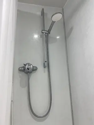 a shower with a shower head on a wall at Prime Duloch Bridge View by TBA in Dunfermline