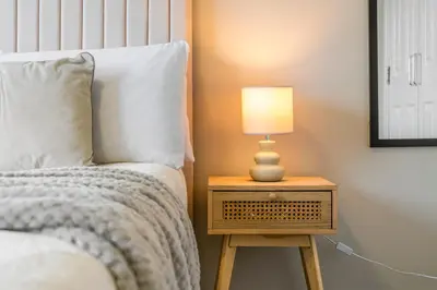 a bedroom with a bed and a lamp on a night stand at Modern 5 Bedroom Townhouse with Free Parking in Glasgow