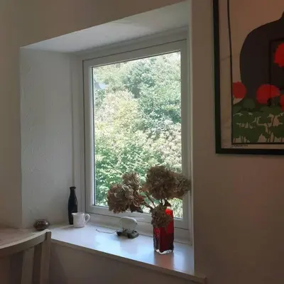 a window with a vase of flowers on a window sill at Peaceful and Stunning Waterside Location in Helensburgh