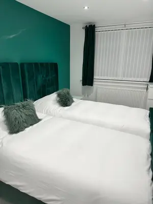 a large white bed with two pillows on it at Doralan in Bishopbriggs