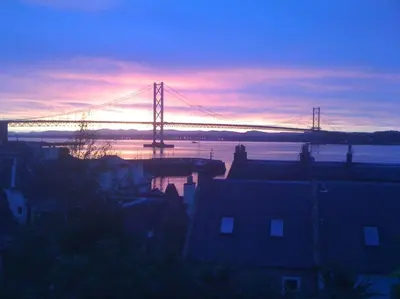 a bridge over a body of water with a sunset at The Nook, Studio Apartment, South Queensferry in Queensferry