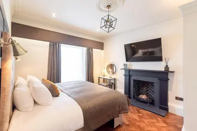 a bedroom with a bed and a fireplace at King Street Aparthotel in Stirling
