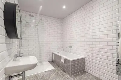 a white bathroom with a sink and a bath tub at King Street Aparthotel in Stirling