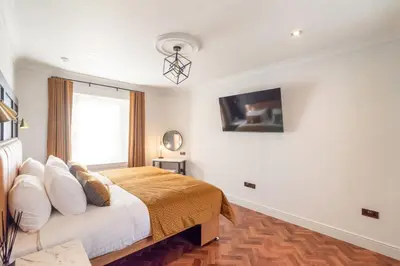 a bedroom with a bed and a window at King Street Aparthotel in Stirling