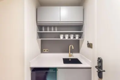 a small kitchen with a sink and shelves at King Street Aparthotel in Stirling