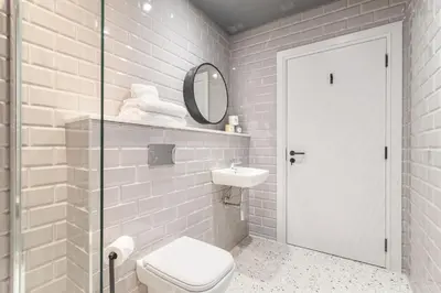 a bathroom with a toilet and a sink and a mirror at King Street Aparthotel in Stirling