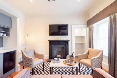 a living room with two chairs and a fireplace at King Street Aparthotel in Stirling