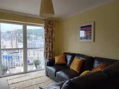 a living room with a couch and a large window at Little Bay View in Oban