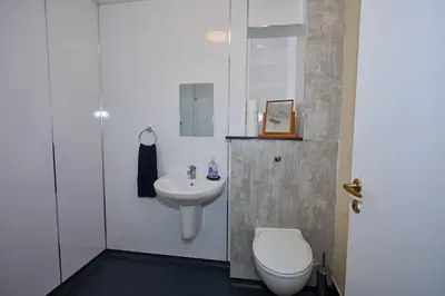 a white bathroom with a toilet and a sink at Little Bay View in Oban