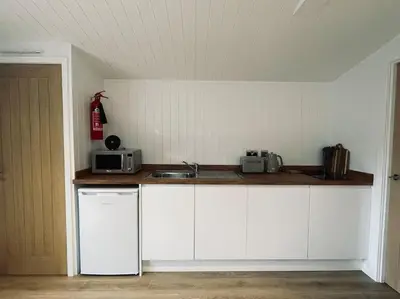 a kitchen with white cabinets and a counter top at West Highland Snug in Kinlochleven
