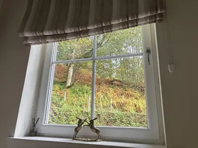 a window with a statue sitting on a window sill at The Heathers in Killin