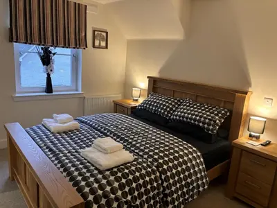 a bedroom with a bed with two towels on it at The Heathers in Killin