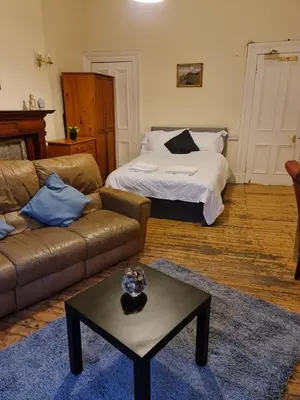 a living room with a couch and a bed at Haymarket Station Rooms in Edinburgh
