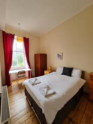 a bedroom with a large bed and a window at Haymarket Station Rooms in Edinburgh