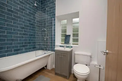 a bathroom with a toilet and a tub and a sink at Historical Holmehill Lodge in Dunblane