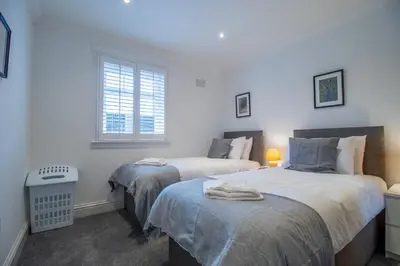 a bedroom with two beds and a window at The Brigg in Coatbridge