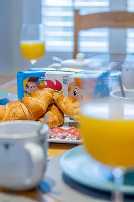 a table with a plate of bread and orange juice at The Brigg in Coatbridge
