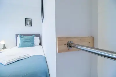 a bed in a room with a pole next to it at The Brigg in Coatbridge