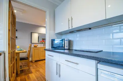 a kitchen with white cabinets and a counter top at The Brigg in Coatbridge