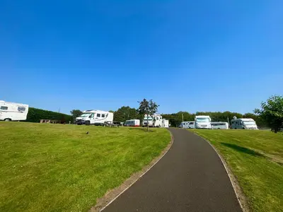 a winding road in front of a group of rvs at Red Deer Village Holiday Park - 3 Bedroom, Self-Catering Holiday Home in Steps