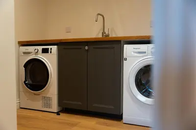 a kitchen with a washing machine and a washer and dryer at Forest Corner Luxury Home with Hot Tub in North Ballachulish