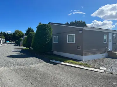 a house on a street next to a road at Red Deer Village Holiday Park - 3 Bedroom, Self-Catering Chalet in Steps