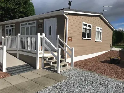 a tiny house with a porch and a staircase at Red Deer Village Holiday Park - 3 Bedroom, Self-Catering Chalet in Steps