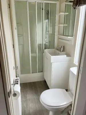 a bathroom with a shower and a toilet and a sink at Red Deer Village Holiday Park - 3 Bedroom, Self Catering Static Caravan in Steps
