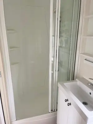 a white bathroom with a shower and a sink at Red Deer Village Holiday Park - 3 Bedroom, Self Catering Static Caravan in Steps