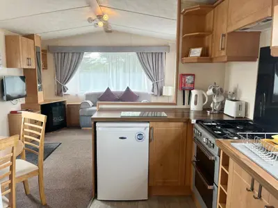 a kitchen with a white refrigerator and a stove at Red Deer Village Holiday Park - 3 Bedroom, Self Catering Static Caravan in Steps